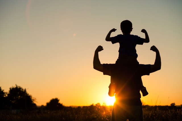 son on dads shoulders sunset